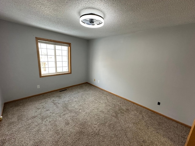 unfurnished room with carpet flooring and a textured ceiling