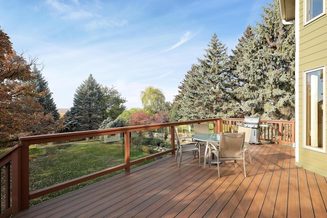 wooden terrace featuring a yard, outdoor dining space, and grilling area