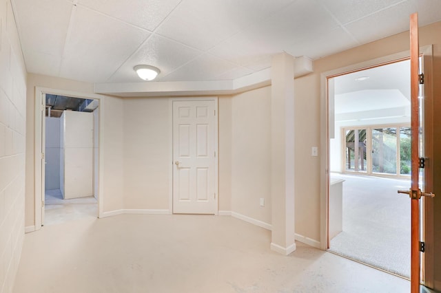 below grade area featuring a paneled ceiling and baseboards