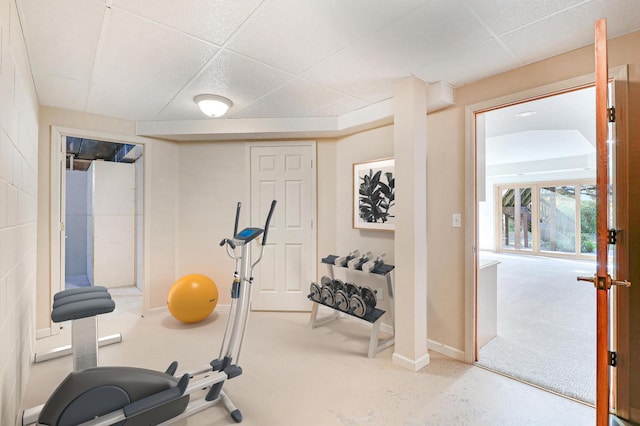 workout room featuring baseboards and a drop ceiling