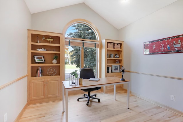 office space featuring light wood-style floors, baseboards, and vaulted ceiling