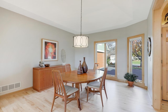 dining area with light wood-style floors, visible vents, and baseboards