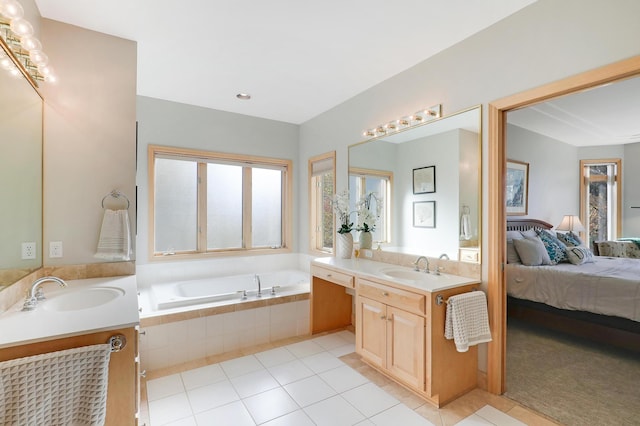 ensuite bathroom featuring tile patterned flooring, two vanities, a sink, a bath, and ensuite bath