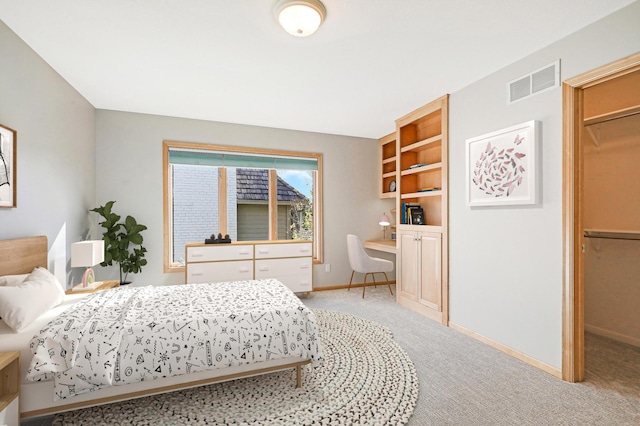 bedroom featuring light carpet, baseboards, visible vents, and built in study area