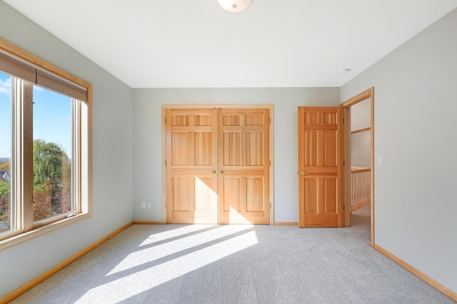 unfurnished bedroom with carpet, a closet, and baseboards