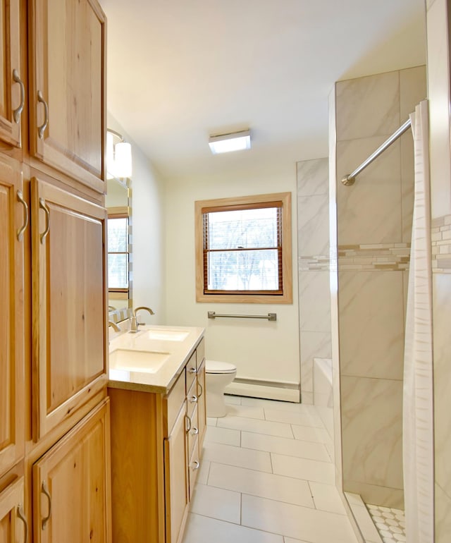 bathroom featuring tile patterned flooring, vanity, toilet, and tiled shower