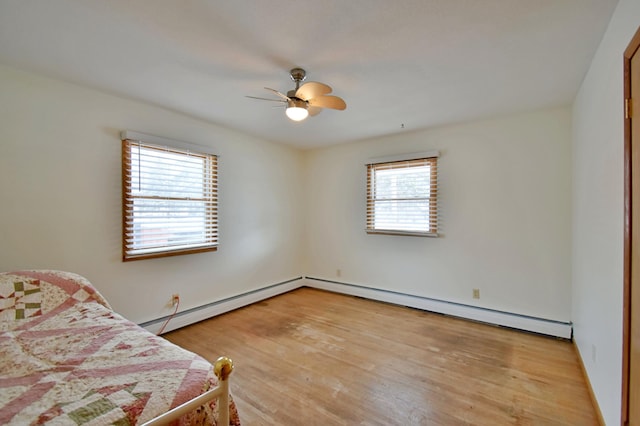 unfurnished bedroom featuring light wood-type flooring, baseboard heating, and ceiling fan