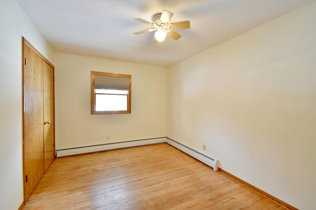 spare room with ceiling fan, light hardwood / wood-style floors, and a baseboard heating unit