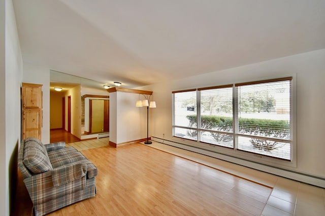 sitting room with light hardwood / wood-style flooring and a baseboard heating unit