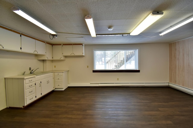 kitchen featuring white cabinets, dark hardwood / wood-style flooring, sink, and a baseboard heating unit