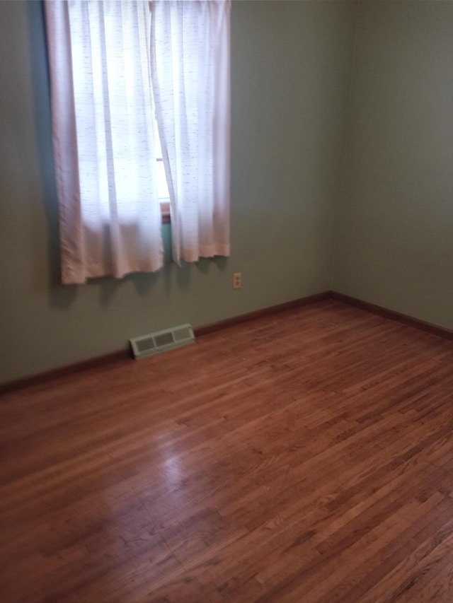 unfurnished room with dark hardwood / wood-style flooring