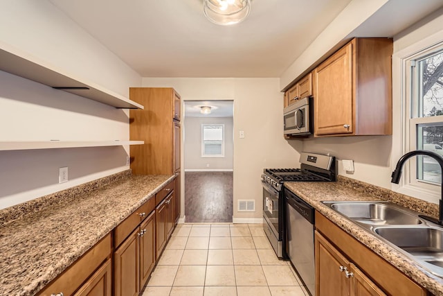 kitchen featuring sink, light tile patterned floors, plenty of natural light, and appliances with stainless steel finishes