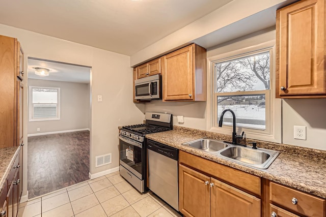 kitchen with light tile patterned floors, stainless steel appliances, and sink