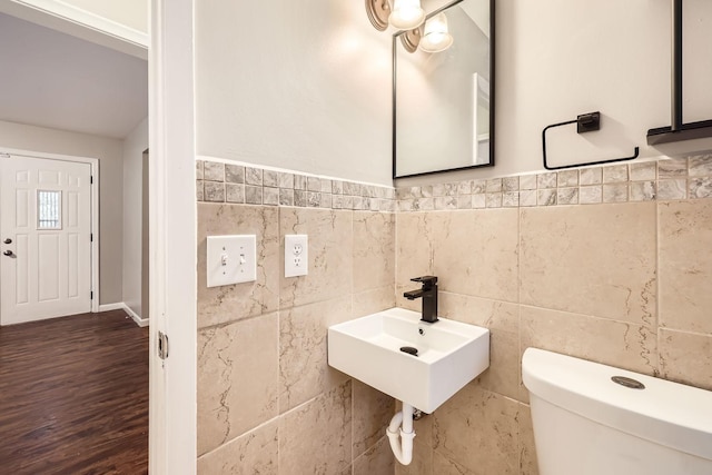 bathroom featuring sink, toilet, and tile walls