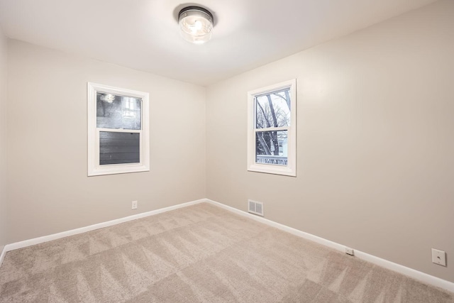 unfurnished room featuring light carpet