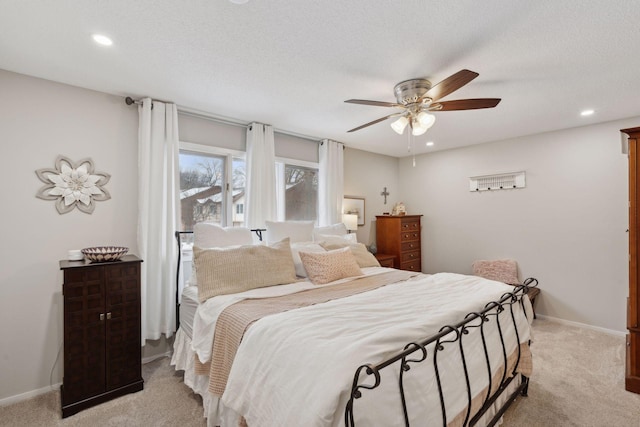 bedroom with ceiling fan, a textured ceiling, and light carpet