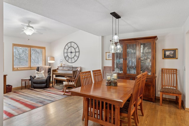 dining space featuring a textured ceiling, ceiling fan, and hardwood / wood-style floors