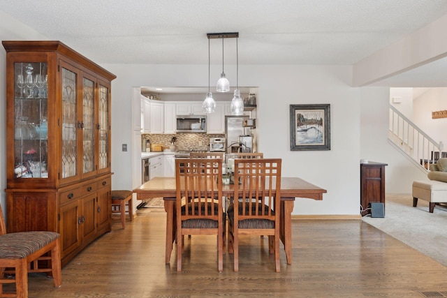 dining room featuring a textured ceiling and hardwood / wood-style floors