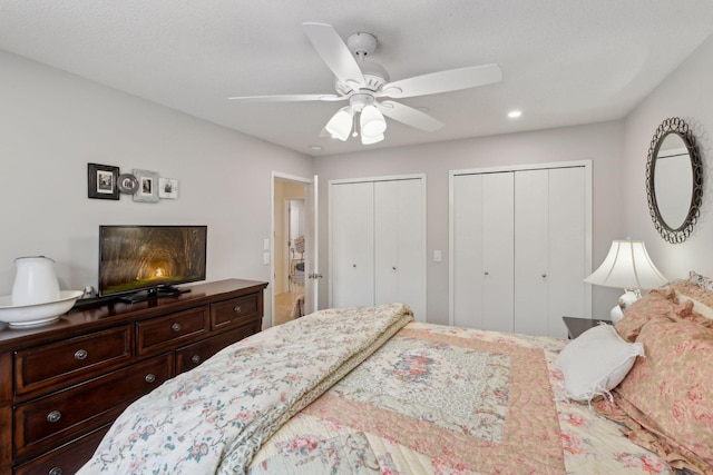 bedroom featuring ceiling fan and multiple closets