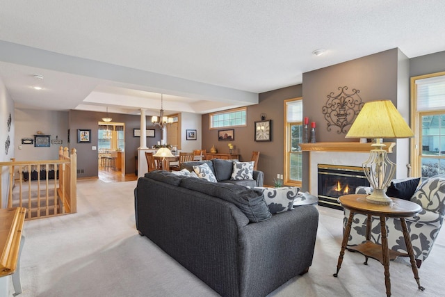 carpeted living room with a raised ceiling and a notable chandelier