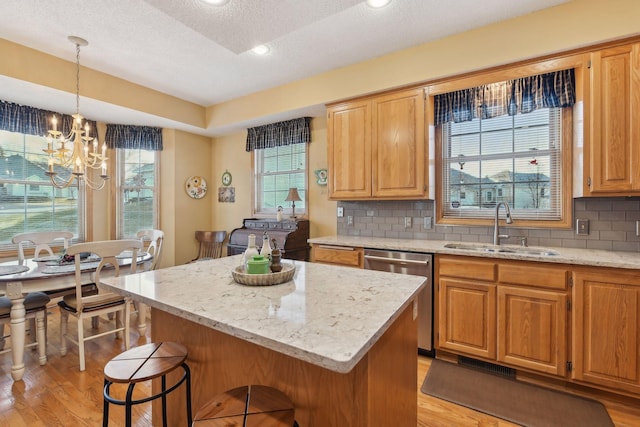 kitchen featuring tasteful backsplash, sink, a center island, and dishwasher