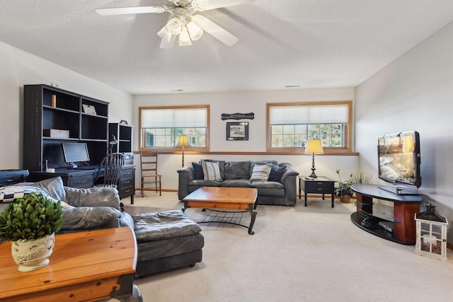 carpeted living room featuring ceiling fan, a textured ceiling, and a wealth of natural light