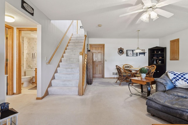 living room featuring ceiling fan, light carpet, and a textured ceiling