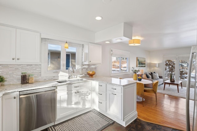 kitchen with stainless steel dishwasher, white cabinetry, sink, and a wealth of natural light