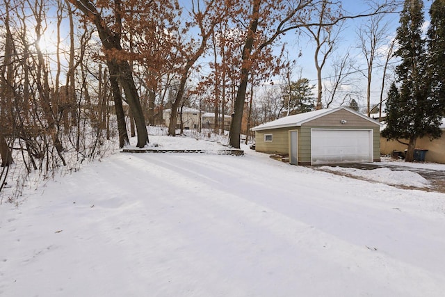 snowy yard with an outbuilding and a garage