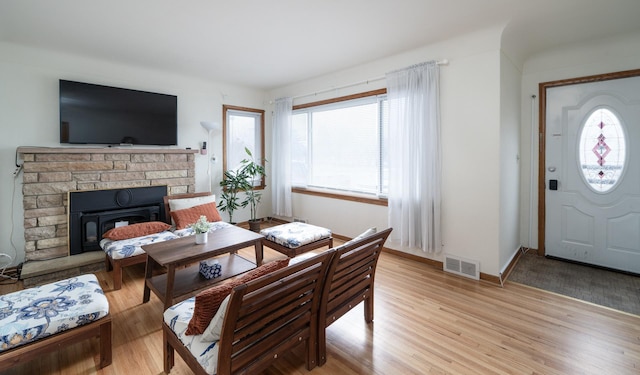 living room with light wood finished floors, visible vents, and baseboards