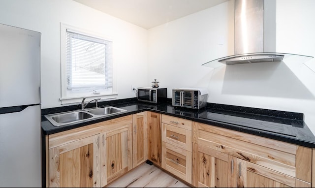 kitchen featuring sink, wall chimney exhaust hood, stainless steel fridge, black stovetop, and light wood-type flooring