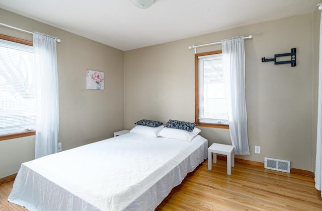 bedroom featuring multiple windows and light hardwood / wood-style flooring