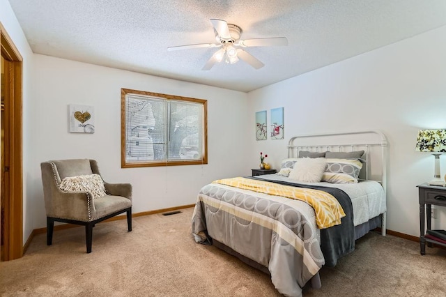 carpeted bedroom with ceiling fan and a textured ceiling