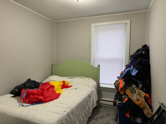 carpeted bedroom with a textured ceiling and a baseboard radiator