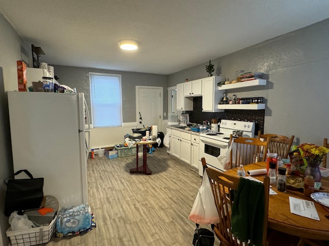 kitchen with tasteful backsplash, white cabinets, light hardwood / wood-style floors, and white appliances