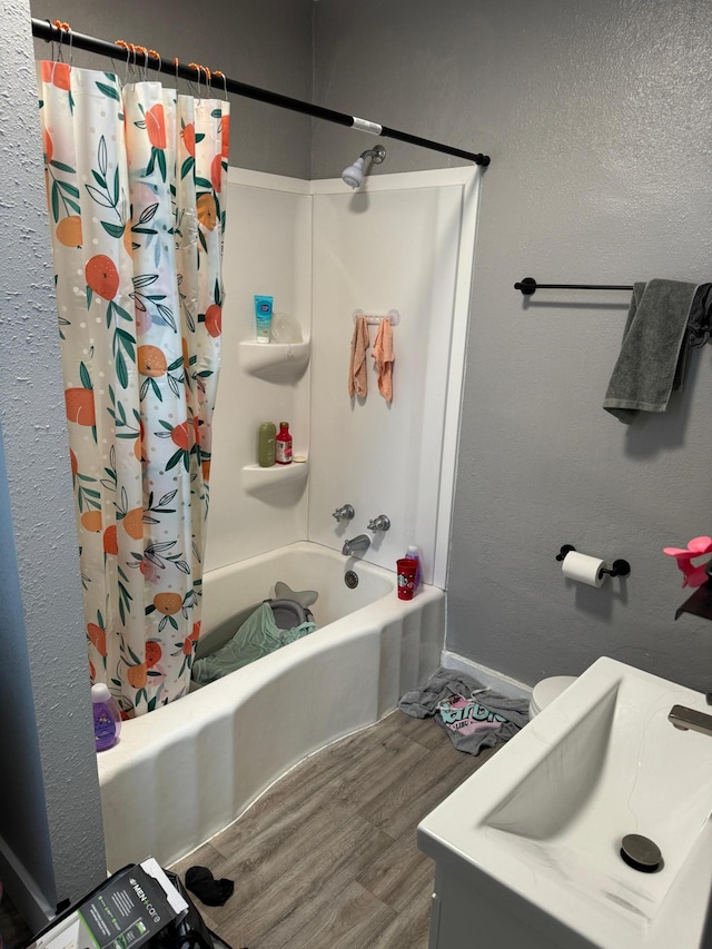 bathroom featuring hardwood / wood-style flooring, sink, and shower / tub combo with curtain