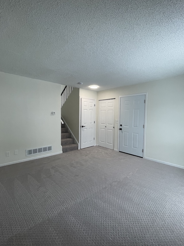 carpeted spare room featuring a textured ceiling