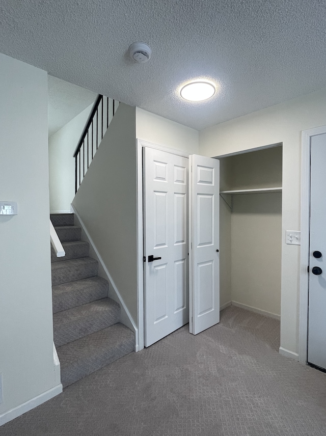 interior space with a textured ceiling and carpet floors