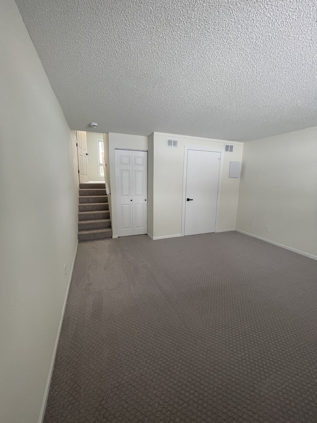 basement featuring carpet flooring and a textured ceiling