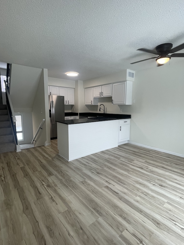 kitchen featuring kitchen peninsula, stainless steel refrigerator with ice dispenser, ceiling fan, light hardwood / wood-style flooring, and white cabinetry