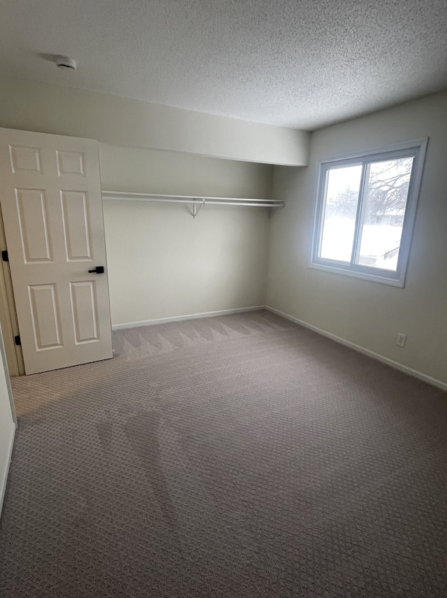 unfurnished bedroom with carpet floors, a textured ceiling, and a closet