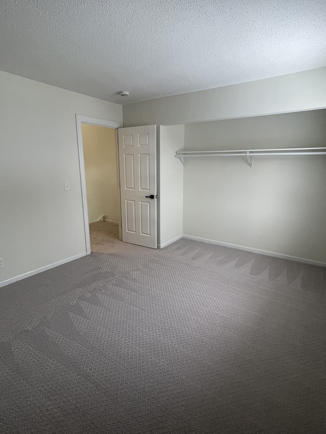 unfurnished bedroom with carpet, a textured ceiling, and a closet