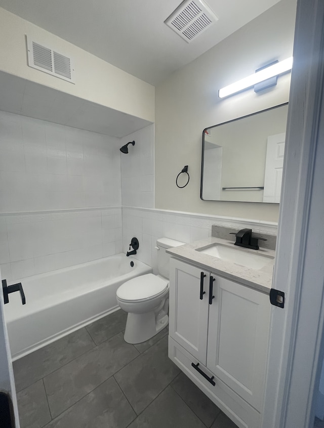 full bathroom with vanity, shower / bathing tub combination, tile walls, tile patterned flooring, and toilet