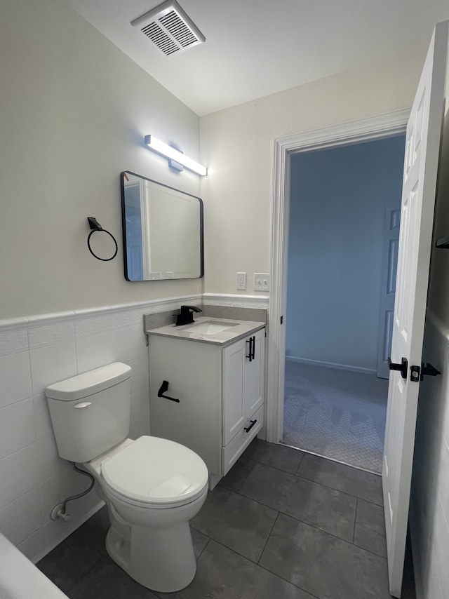 bathroom featuring tile patterned flooring, vanity, and toilet