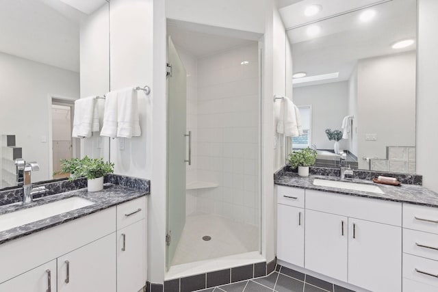 bathroom with tile patterned floors, a shower with door, and vanity