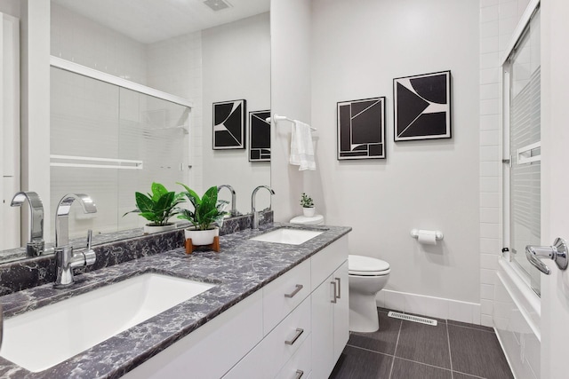 full bathroom with vanity, combined bath / shower with glass door, tile patterned floors, and toilet