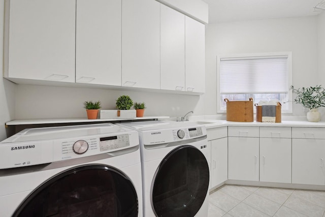 laundry room featuring sink, light tile patterned floors, cabinets, and independent washer and dryer