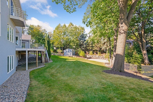 view of yard with a wooden deck, a patio, and a storage unit