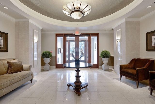 foyer entrance with light tile patterned floors, ornamental molding, a raised ceiling, and french doors