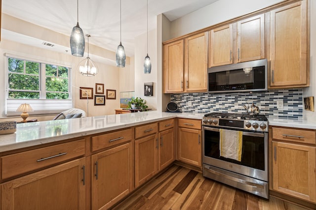 kitchen with tasteful backsplash, decorative light fixtures, kitchen peninsula, and appliances with stainless steel finishes